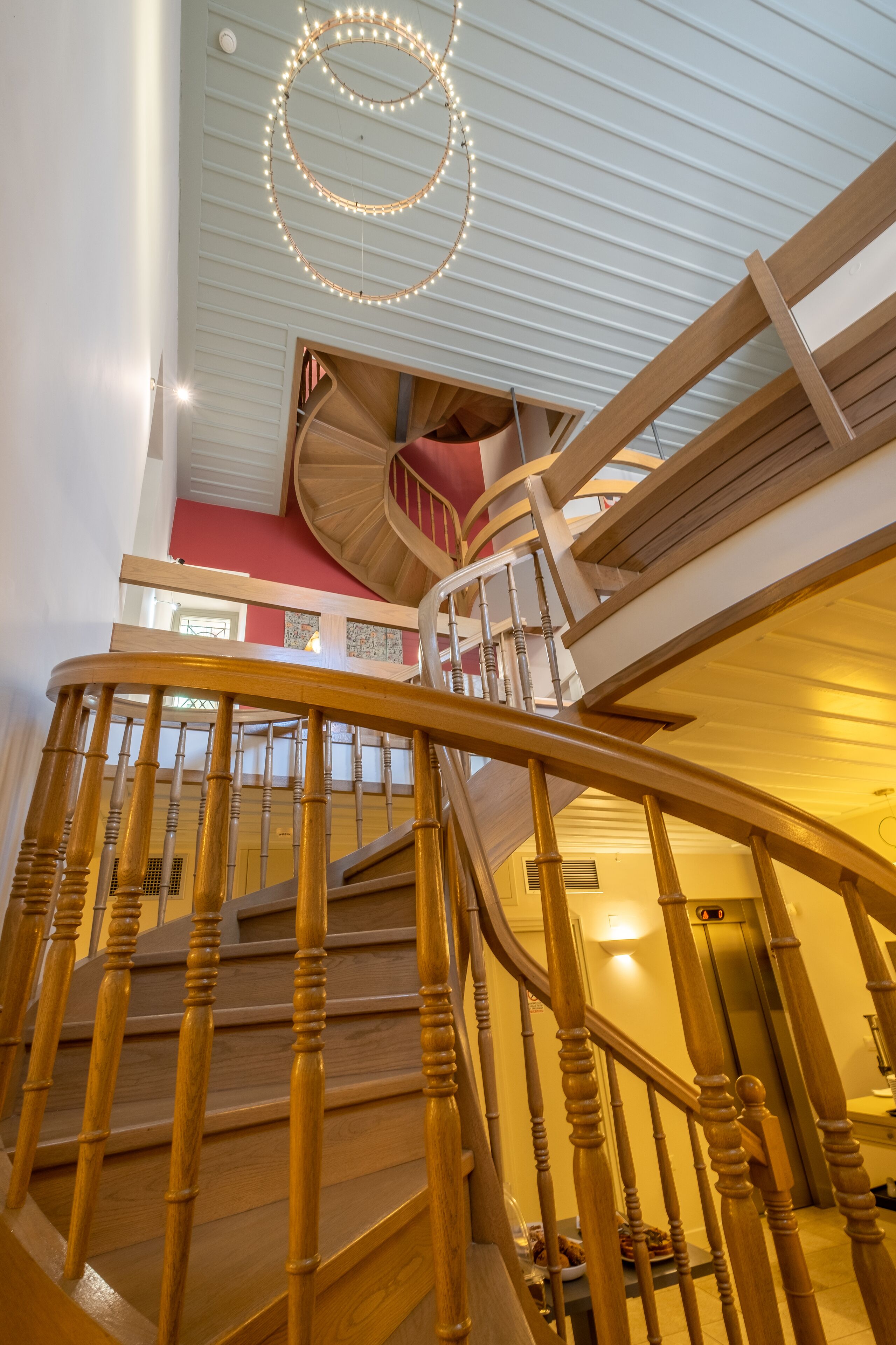 A wooden staircase with a circular light fixture above.