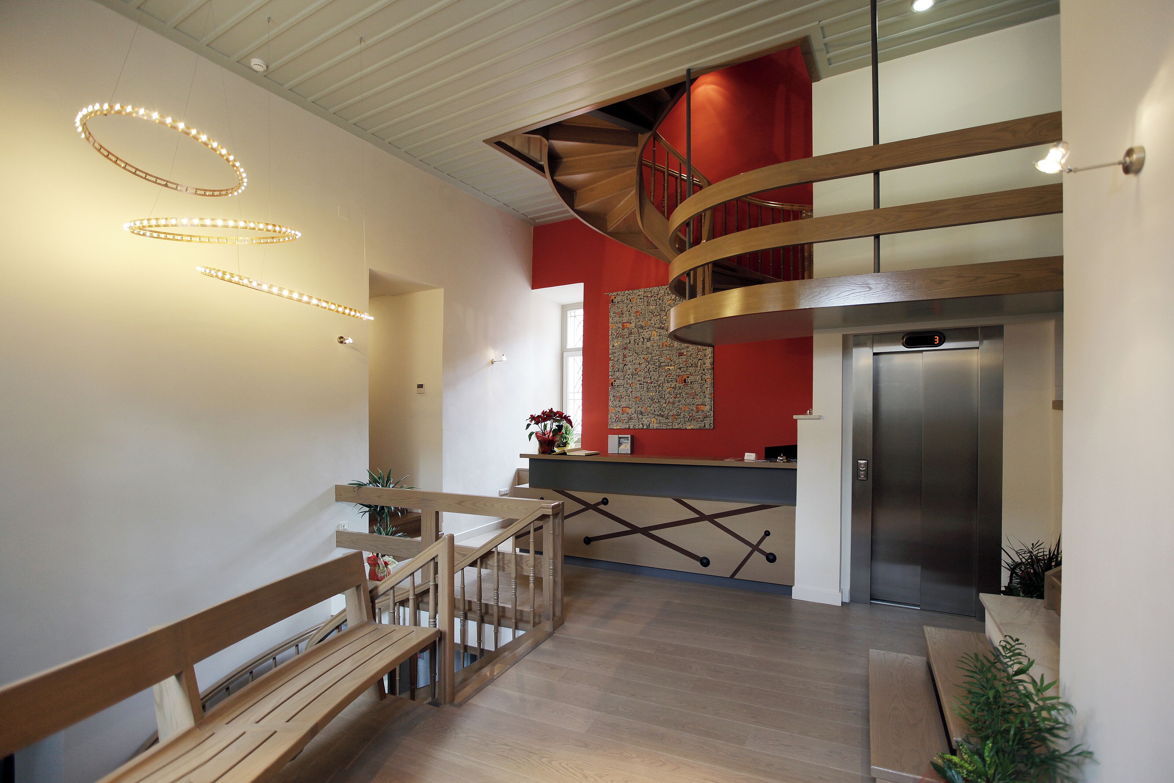 Un interior moderno con una escalera de madera, una zona de cocina y un espacio para comer.