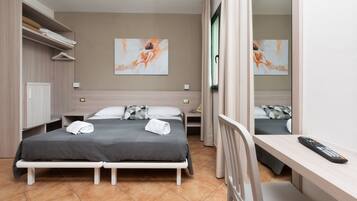 A modern hotel room with two beds, a desk, a chair, and a large mirror.