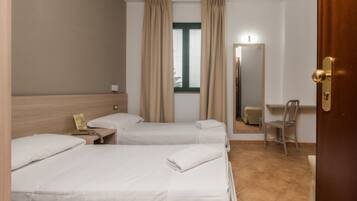 Una habitación de hotel con dos camas, un escritorio, una silla, un espejo y una ventana con cortinas.