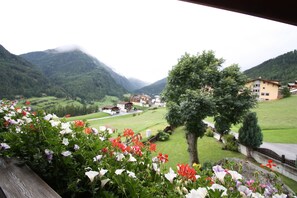 Un paisaje montañoso con vistas a un pueblo y un edificio con balcón.