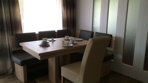 A dining area with a rectangular table, six chairs, and a bench. - Sonnenhang (Soelden)