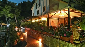 A house with a covered porch, stone walls, and potted plants. - Hotel Villa delle Meraviglie (Maratea)
