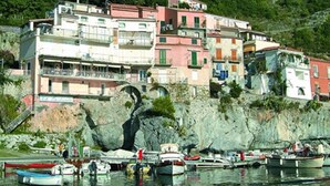 A coastal town with buildings along the waterfront, a statue, and a hill with a statue on top. - Hotel Villa delle Meraviglie (Maratea)