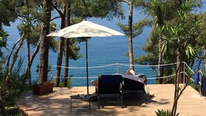 An outdoor seating area with a table and chairs, a canopy, and a view of the sea. - Hotel Villa delle Meraviglie (Maratea)
