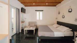 Een slaapkamer met een bed, een aan de muur bevestigde televisie, een raam en een deur.