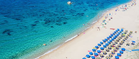 Plage, sable blanc, chaises longues, parasols