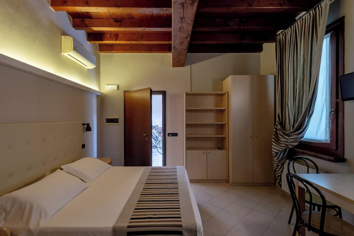 Ein Schlafzimmer mit Bett, Schreibtisch und Kleiderschrank.