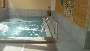 A hot tub with a wooden wall and a tiled floor. - Au Gai Soleil du Mont Aiguille (Chichilianne)