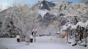 A snow-covered park with trees and a mountain in the background. - Au Gai Soleil du Mont Aiguille (Chichilianne)