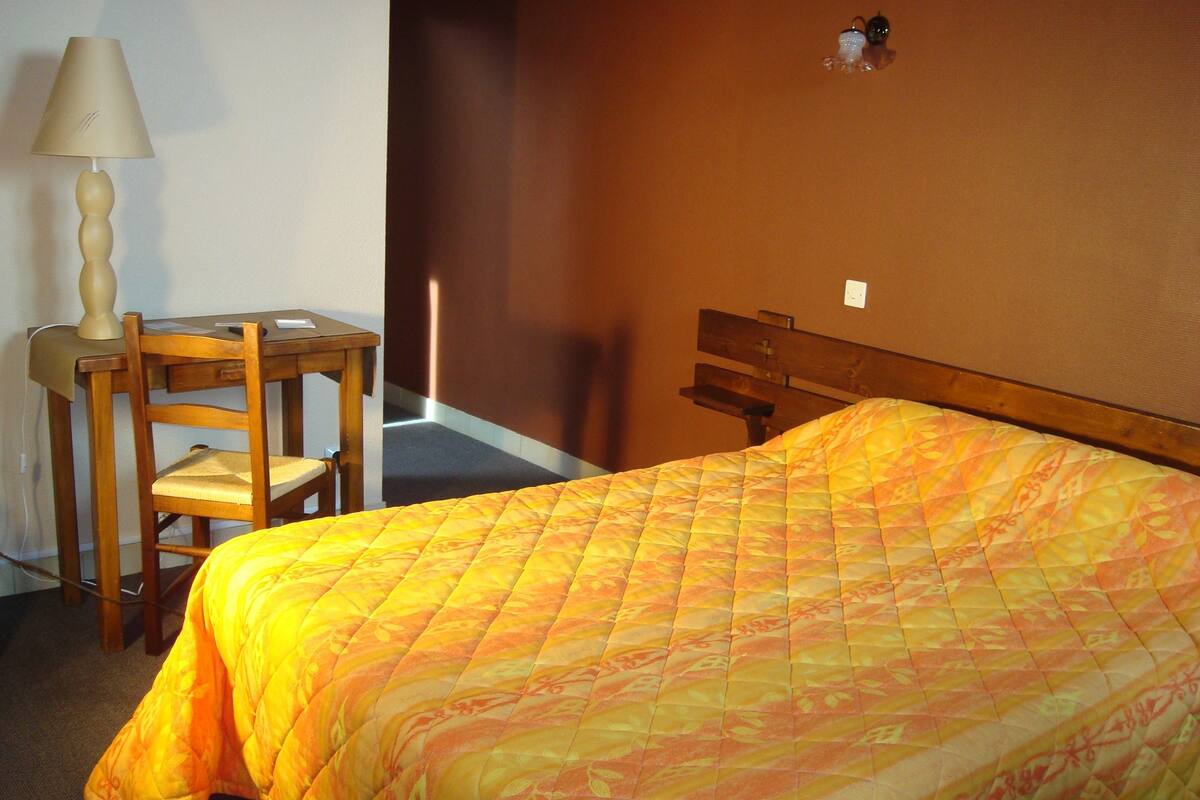 A room with a bed, a desk, and a chair.