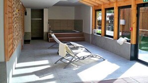 A modern interior with a wooden ceiling, a bed, a chair, and a window with a view of the outdoors. - Au Gai Soleil du Mont Aiguille (Chichilianne)