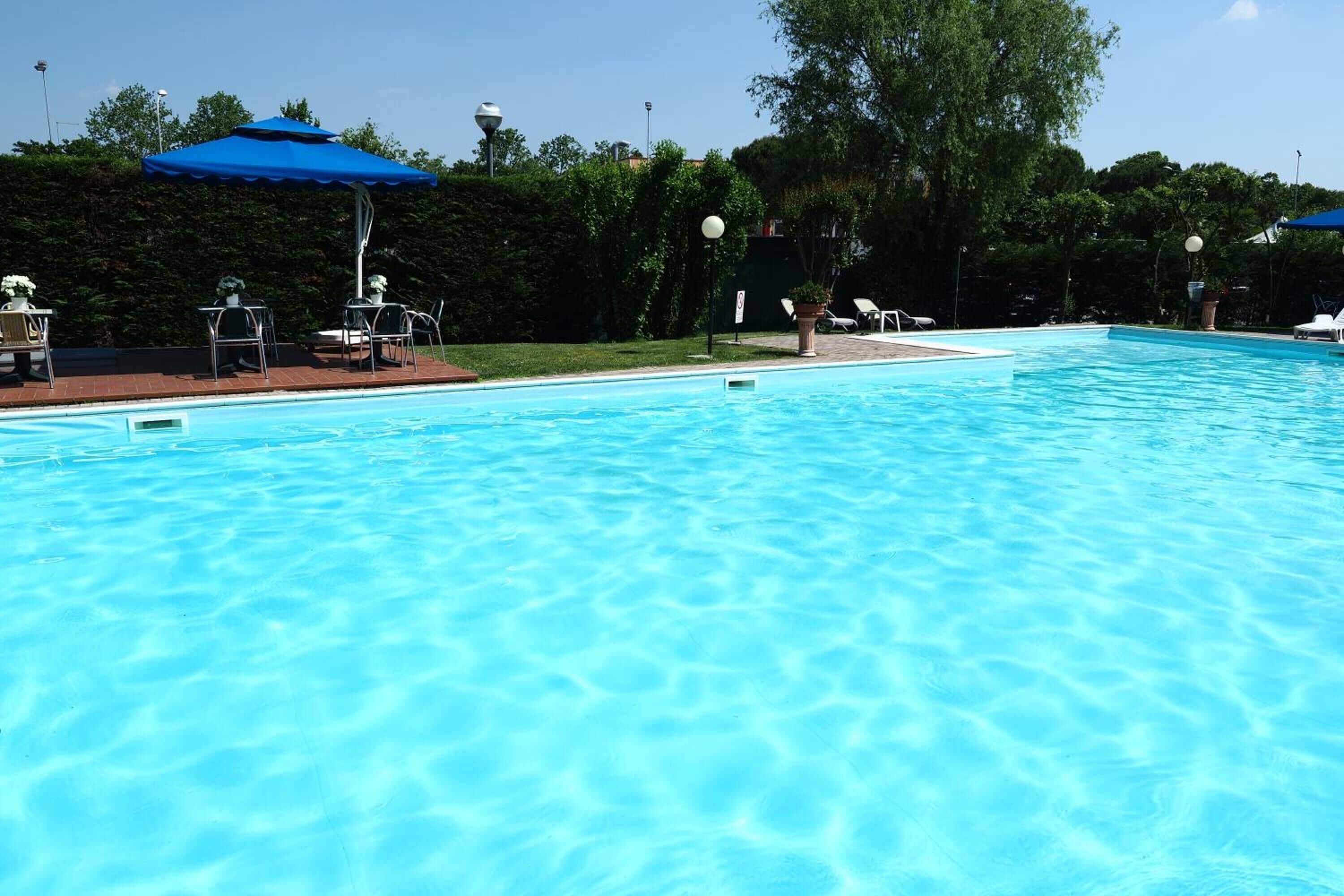 季节性开放的室外游泳池，池畔遮阳伞，日光浴躺椅