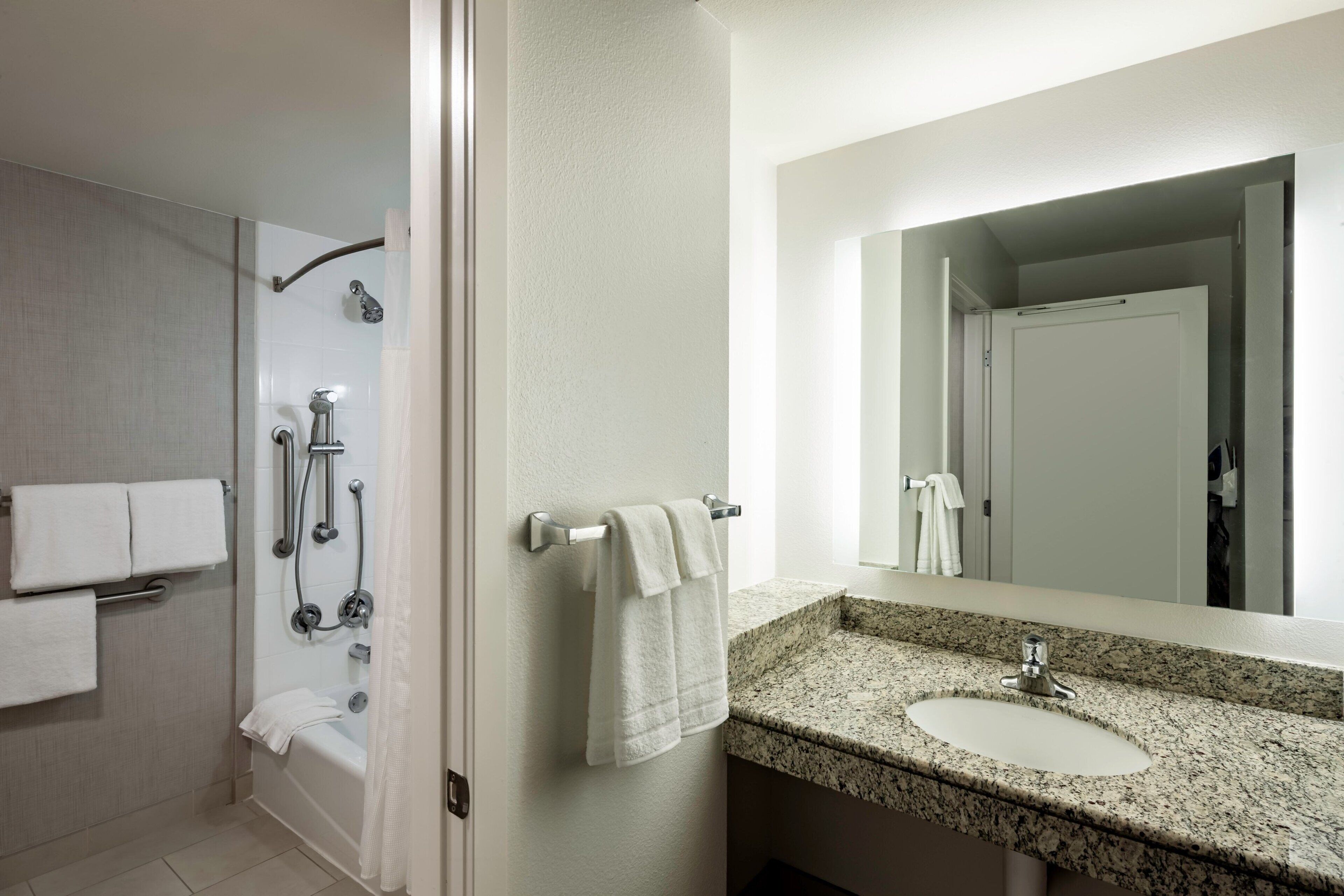 Une salle de bain avec une douche, un lavabo et un miroir.
