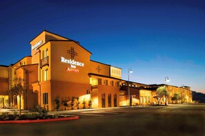 Edificio de un Residence Inn Marriott con una cruz destacada en la fachada, un estacionamiento y un cielo despejado.