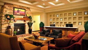 A hotel lobby with a fireplace, seating area, and a reception desk.