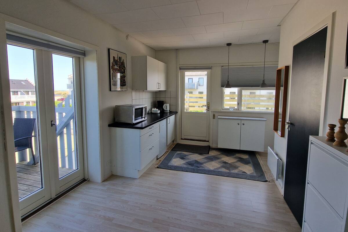 A compact kitchen with white cabinets, a microwave, and a coffee maker.