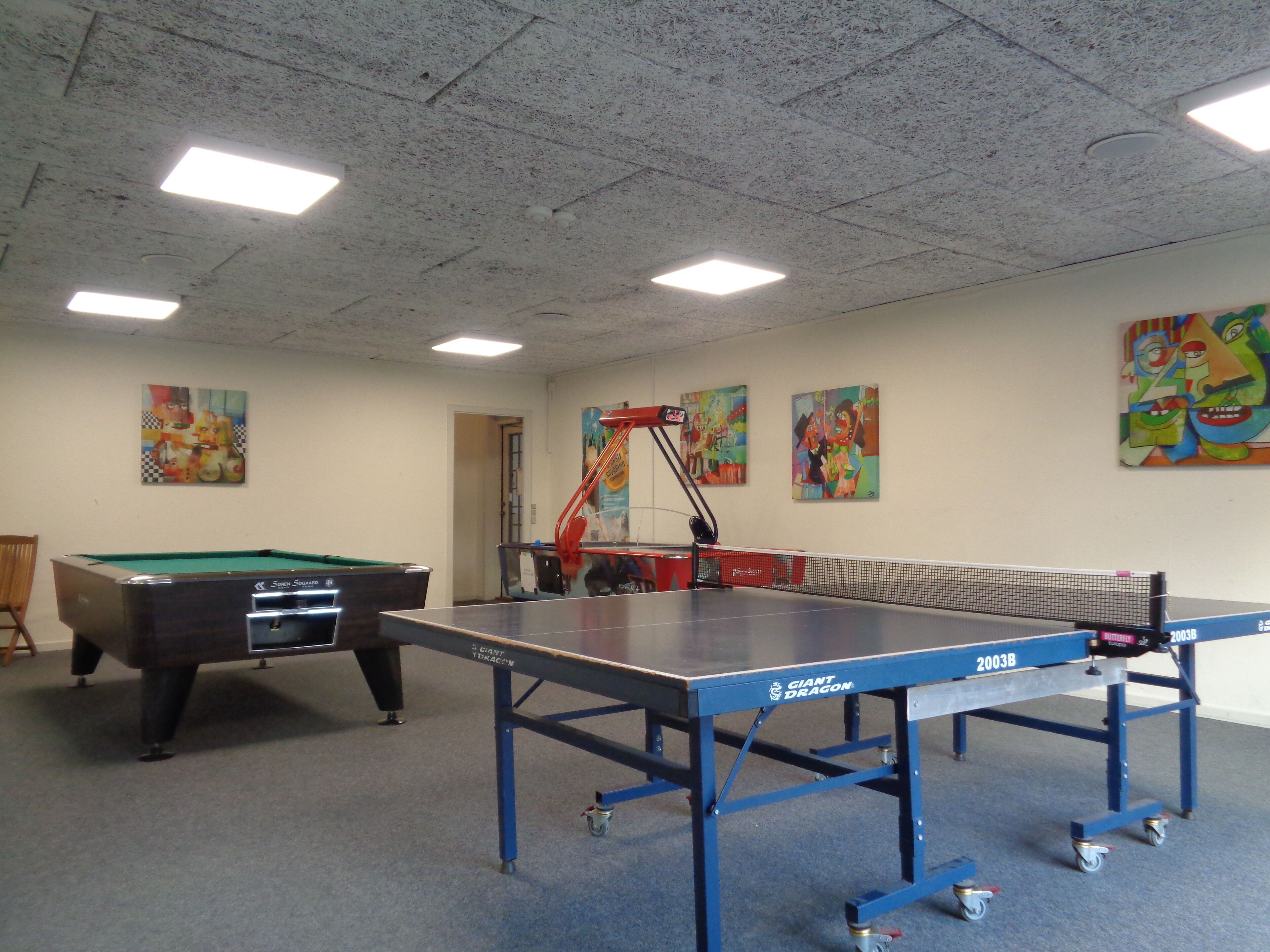 Ein Raum mit Billardtisch, Tischtennisplatte und Poolbillardtisch.