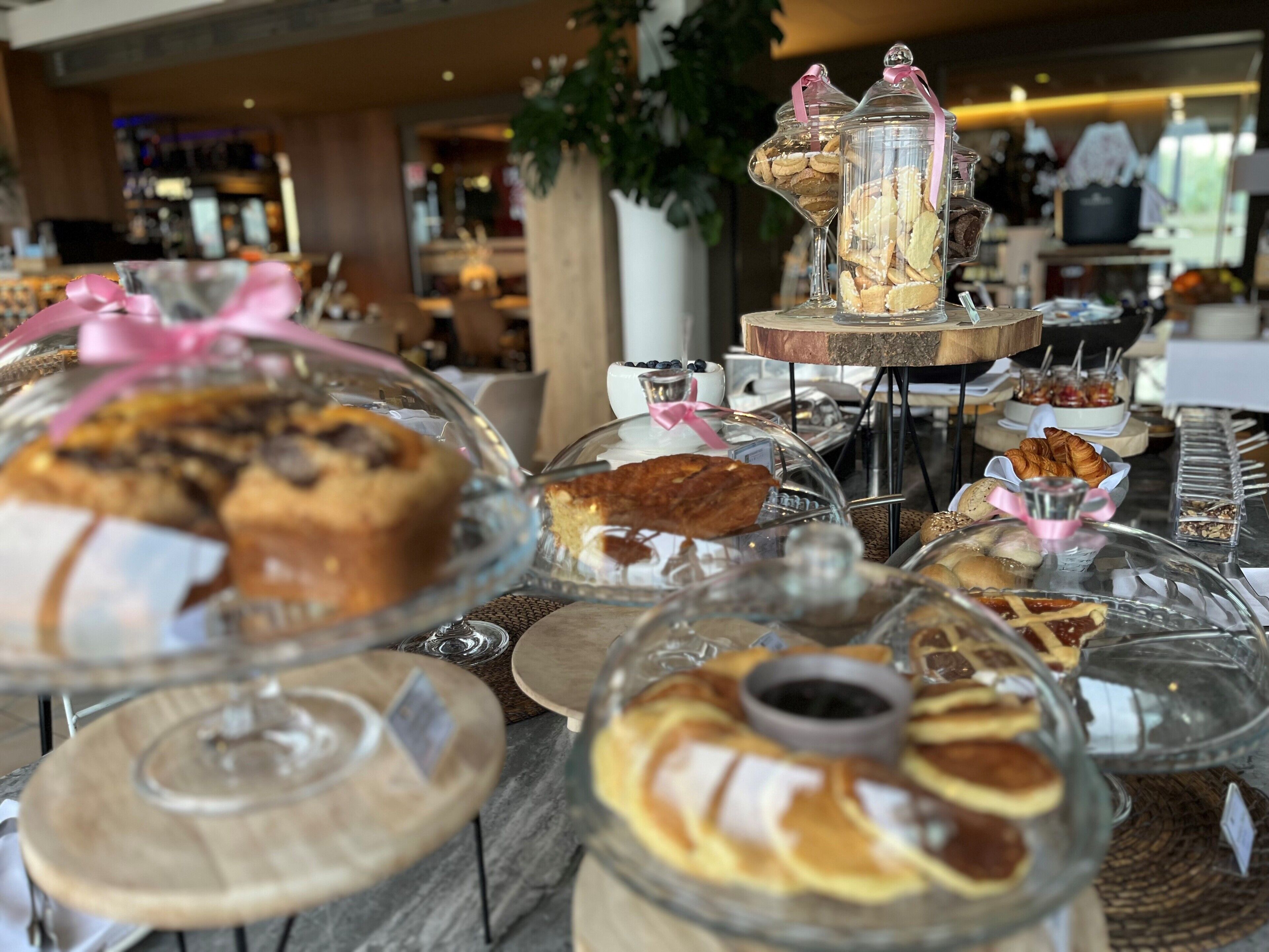 A buffet with various baked goods displayed in glass containers.