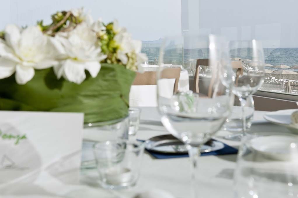 A table set for dining with a view of the ocean.
