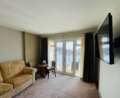 Deluxe Suite, 1 Bedroom, Balcony, Pool View | Living area | 32-inch flat-screen TV with digital channels, TV