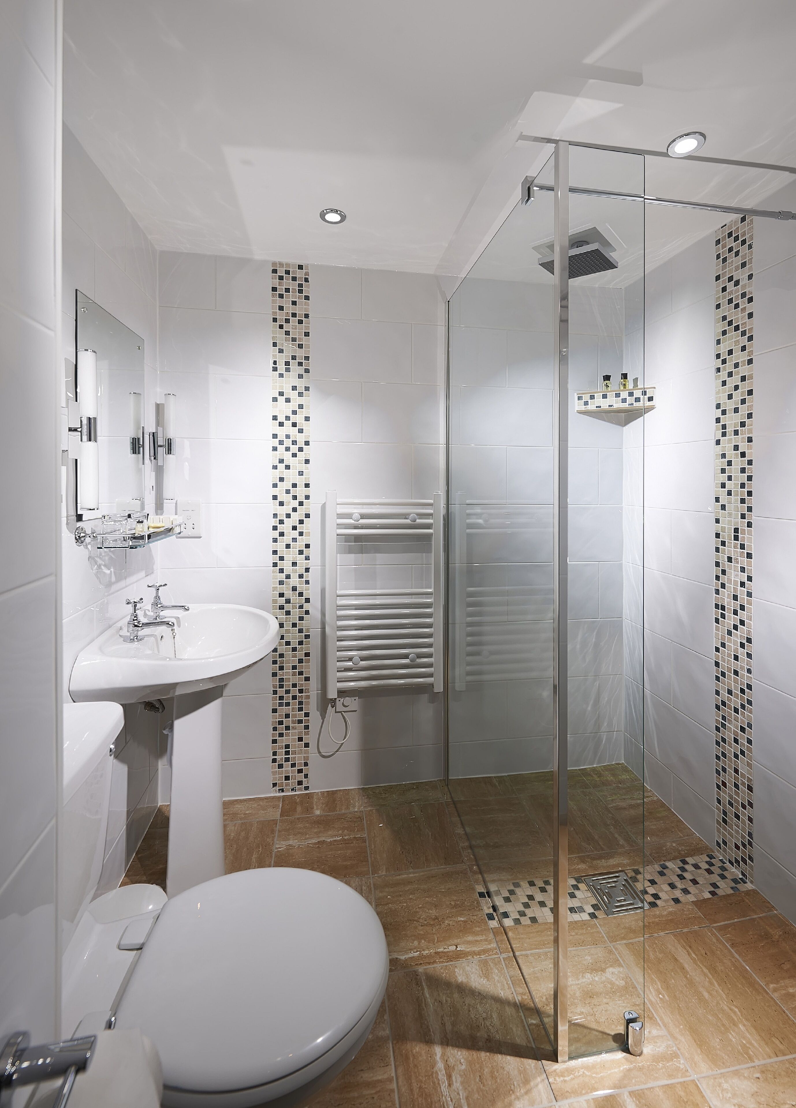 A modern bathroom with a glass-enclosed shower, a white sink, and a toilet.