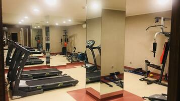 A gym with treadmills, a stationary bike, and weightlifting equipment.
