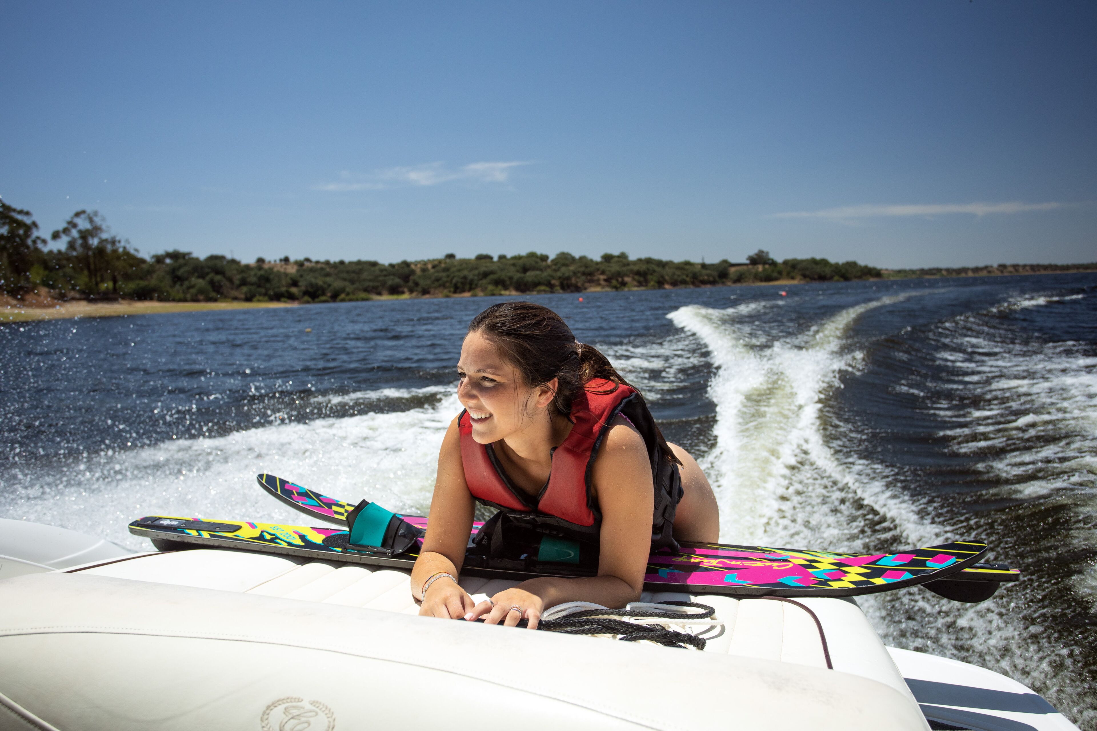 Una persona asseguda en un jet ski, portant un armall salvavides, amb una taula de colors al davant.