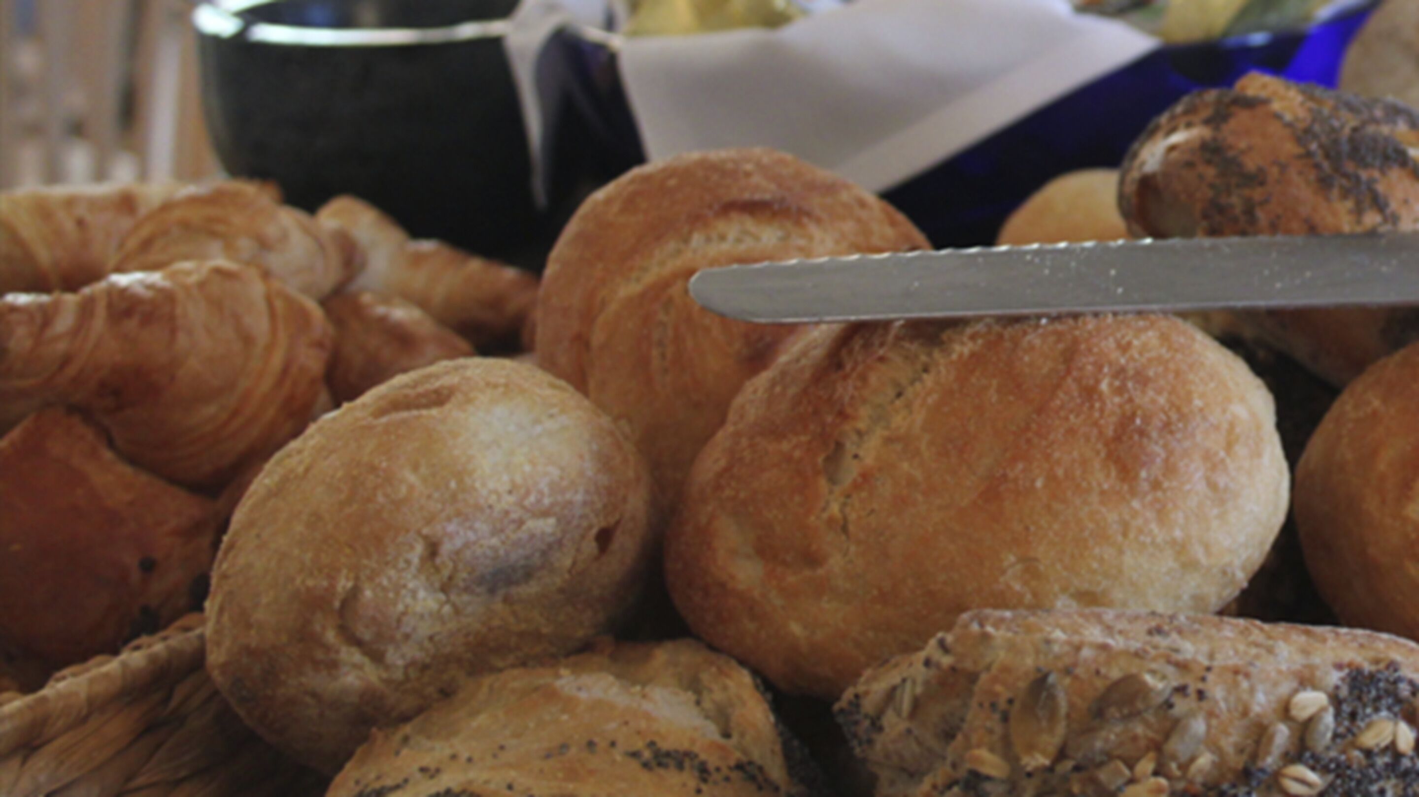 Une variété de produits de boulangerie, notamment des croissants et des petits pains, présentés dans un panier.