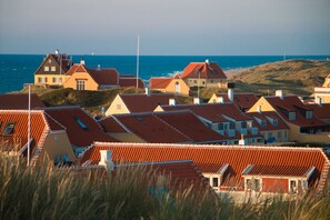 A coastal residential area with houses featuring red-tiled roofs and a view of the sea. - Ruths Hotel (Skagen)