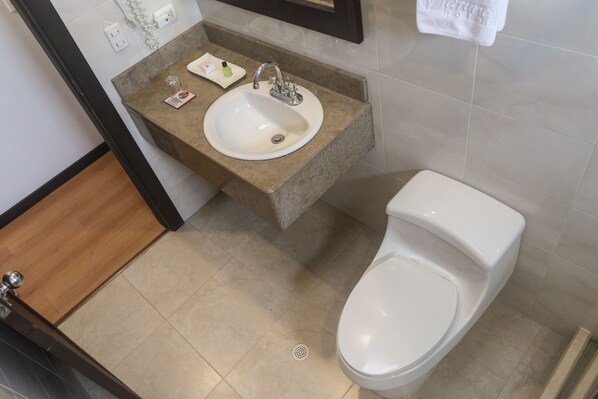 A bathroom with a sink, toilet, and a mirror above the sink.