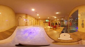 Un área de spa con jacuzzi, zona de estar y recepción.