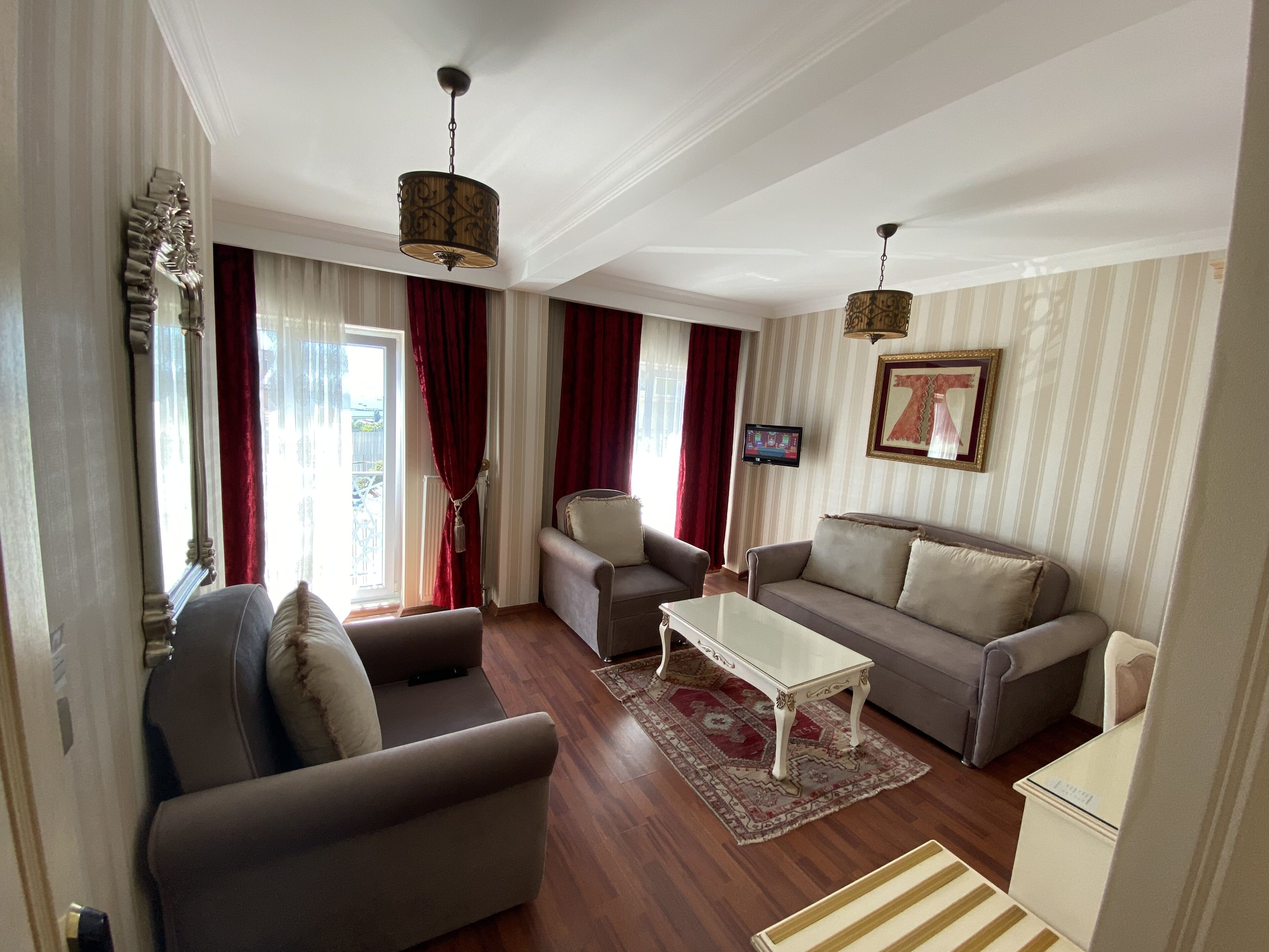 A living room with a sofa, armchairs, a coffee table, and a TV.