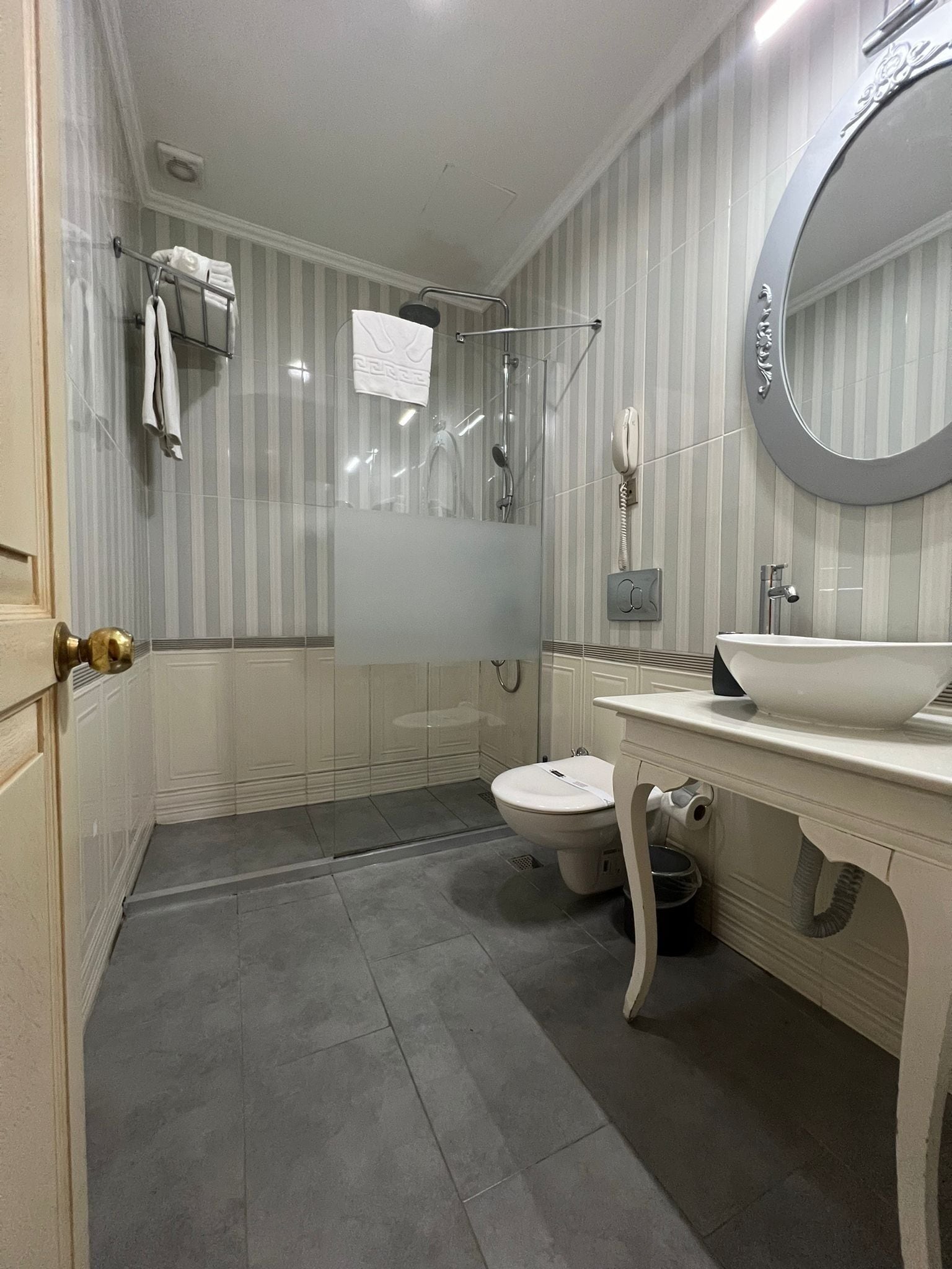 Une salle de bain avec douche, toilettes et lavabo.