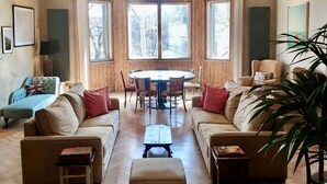 Un salón amplio con una gran mesa de comedor de madera, dos sofás y una mesa de centro.