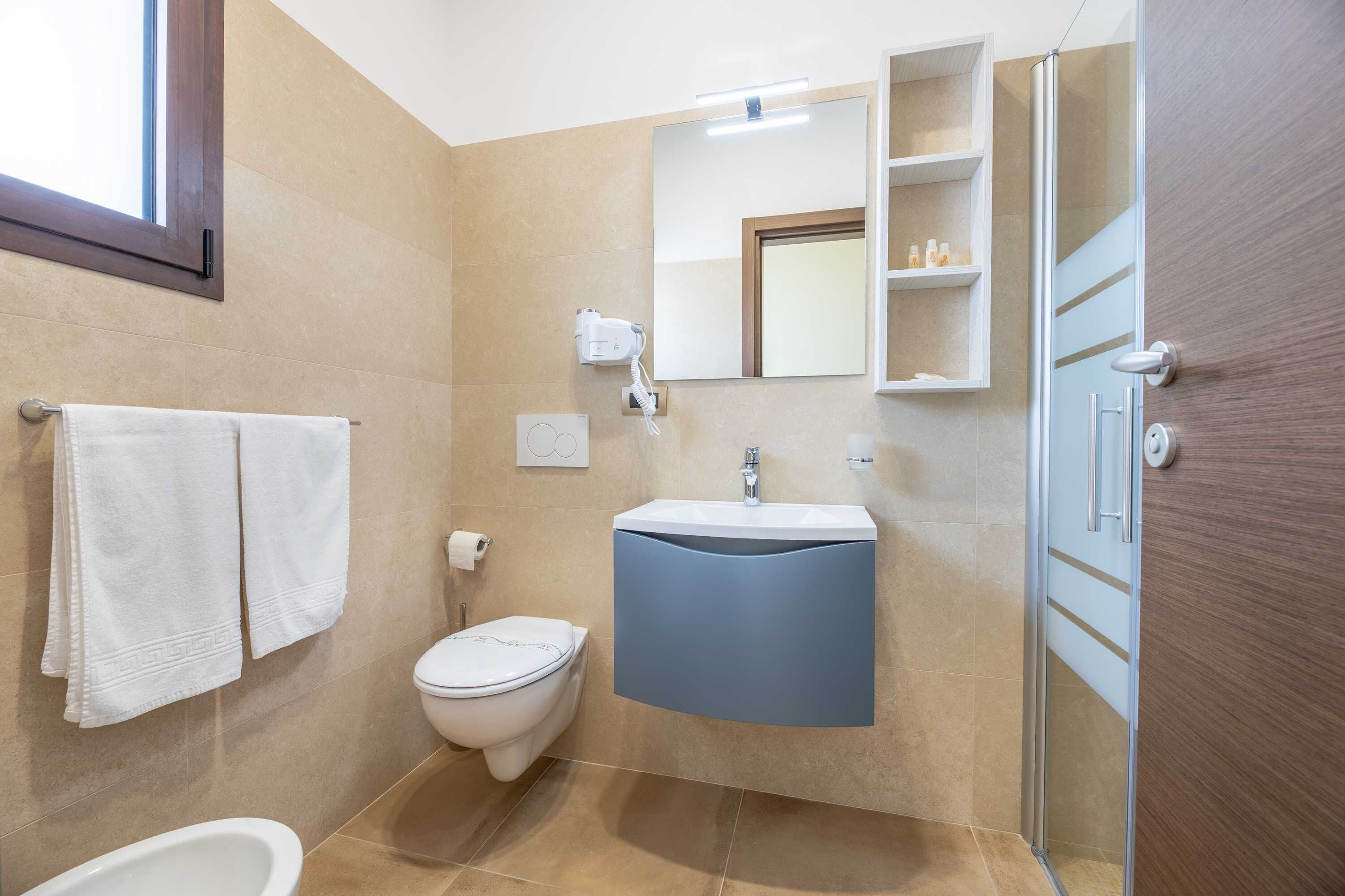 Une salle de bain moderne équipée de toilettes, d’un lavabo et d’une douche.