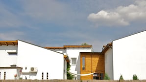 A modern house with a white exterior, wooden accents, and a wooden staircase. - Sunset Apartments (Hajduszoboszlo)