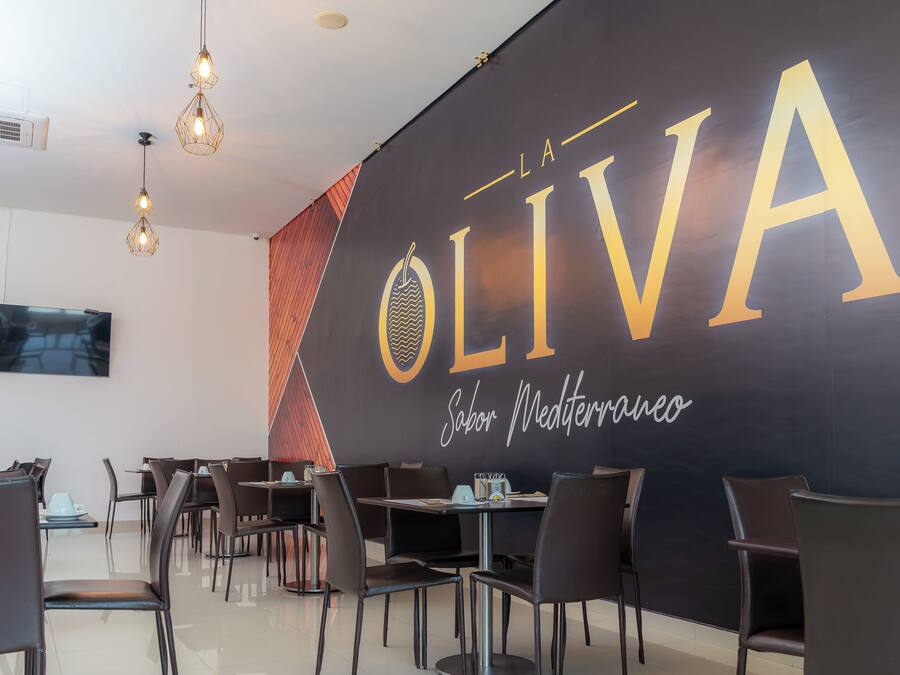 Een moderne eethoek met een groot bord waarop 'OLIVA' en 'Sabor Mediterraneo' staan.