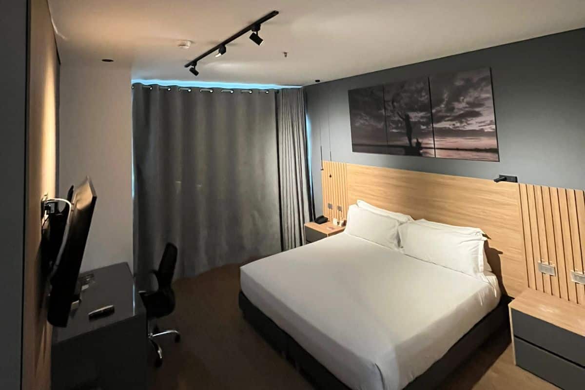Una habitación de hotel moderna con una cama grande, un escritorio y una silla.