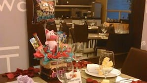 Une table à manger dressée avec des assiettes, des verres et un centre de table décoratif.