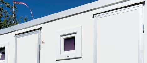 Una estructura portátil blanca con la marca 'GSV', que presenta dos puertas y un ventanal pequeño.