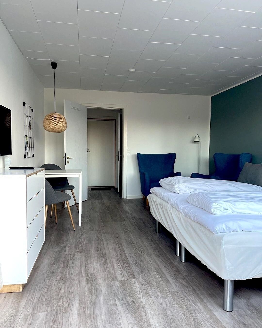 A modern bedroom with a bed, a desk, and a chair.