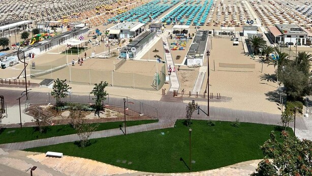 Un hôtel situé en bord de mer, avec plusieurs étages de chambres, une cour intérieure et une vue sur l’océan.