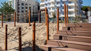 Un bâtiment moderne doté de balcons, d’une promenade en bois et d’une sculpture métallique.