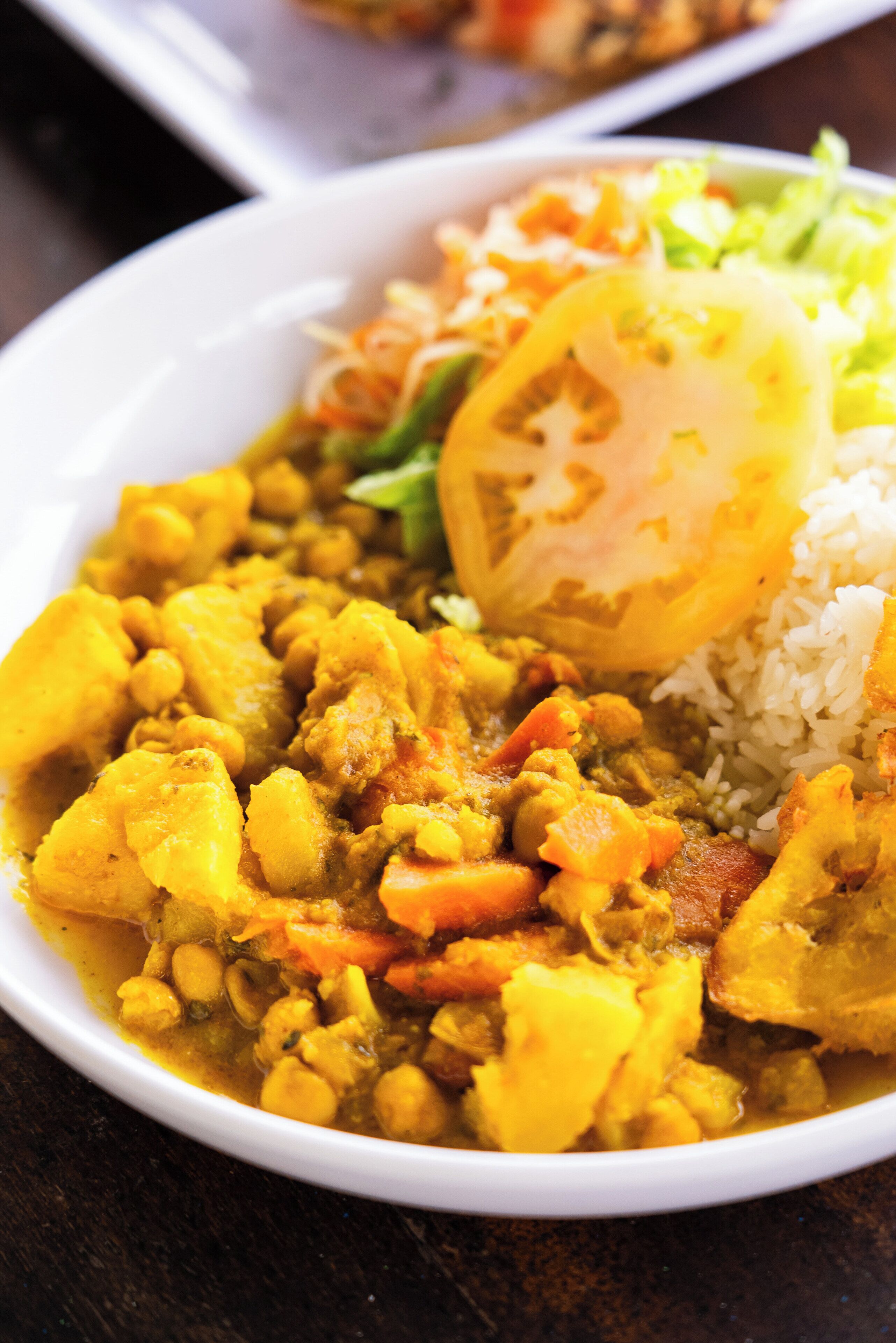 Une assiette de curry accompagnée de riz et de légumes.