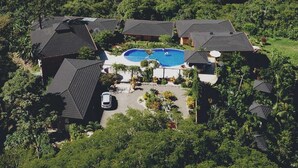 A resort with multiple buildings, a swimming pool, and a view of the ocean and islands. - Eco Boutique Hotel Vista Las Islas Reserva Natural (Paquera)