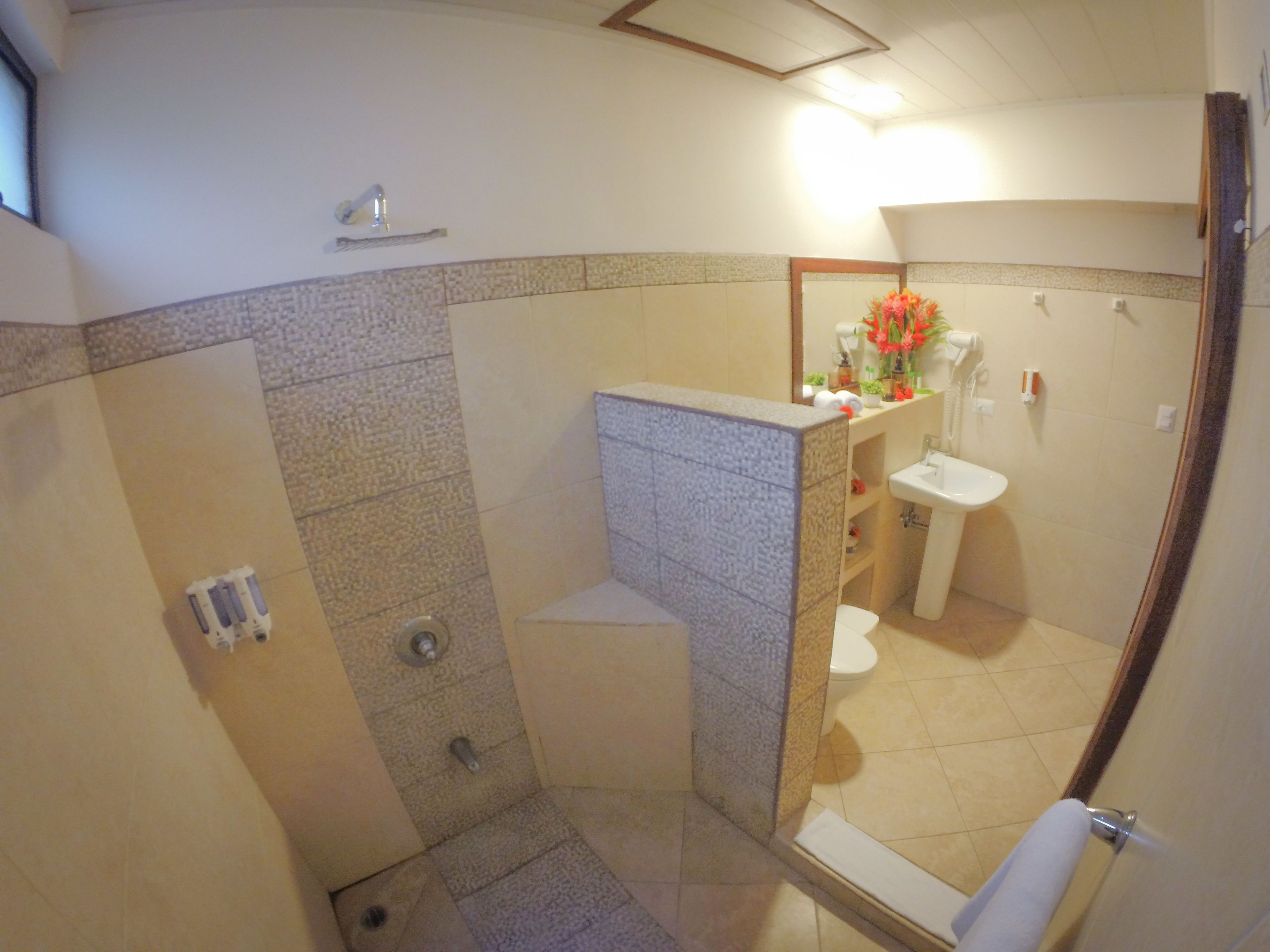 A bathroom with a shower, toilet, and sink.