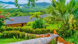 A lush garden with a wooden fence, a sign reading "Condesa", and a view of a mountain and water in the background. - Eco Boutique Hotel Vista Las Islas Reserva Natural (Paquera)