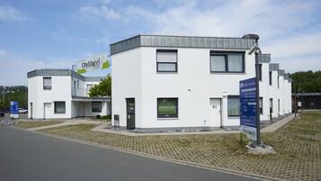 Ein modernes City-Motel Gebäude mit weißer Fassade, zahlreichen Fenstern und einem Schild.