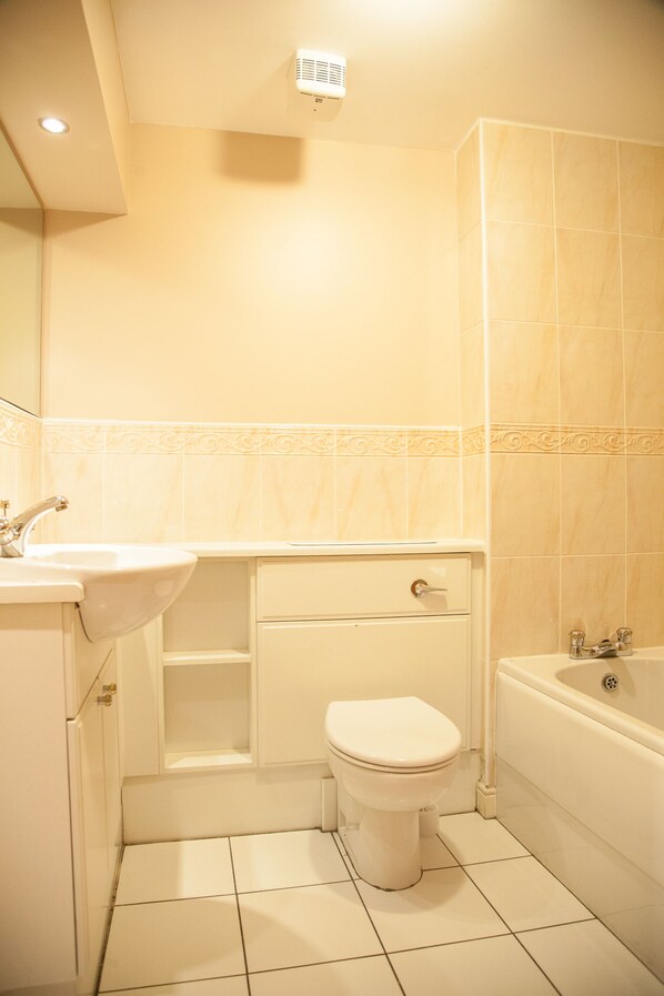 Une salle de bain avec un lavabo, des toilettes et une baignoire.